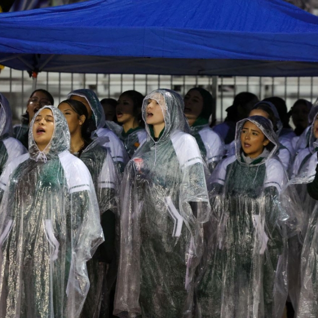 Buena Park cheerleaders call out cheers from a rain shelter