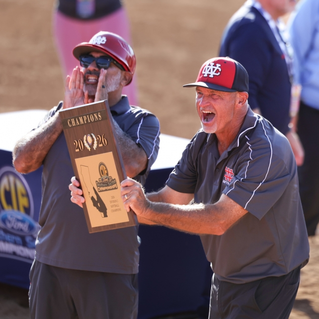 Coach Dale VanDuyn holds up the CIF Championship plaque to players and fans