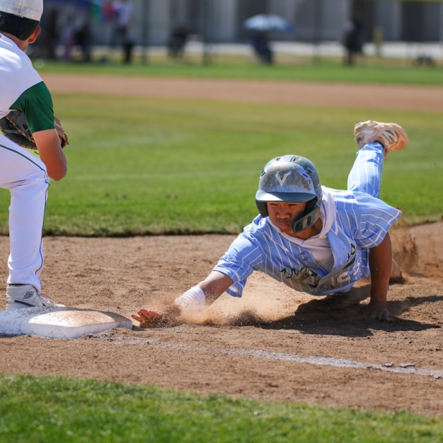 Irvine’s Nico Macalino safely slides back to first base